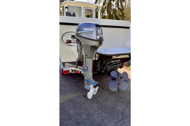Slide: The Image of Boat with Yamaha outboard motor, Osprey Legend 2006 model, parked on pavement. - 23