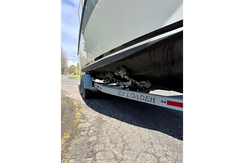 Slide: The Image of Trailer with 2006 Osprey Legend boat on EZ Loader, parked on asphalt. - 24