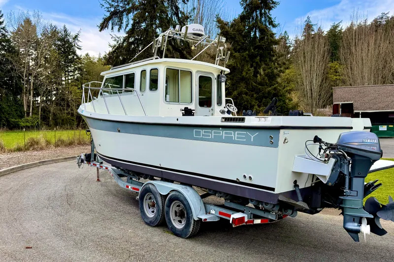 Slide: The Image of 2006 Osprey Legend boat on trailer with Yamaha outboard motor, parked outdoors. - 4