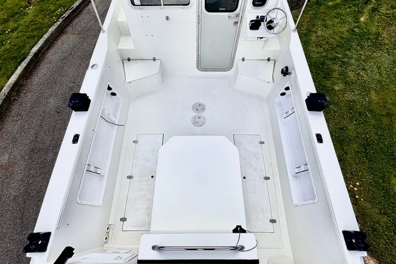 Slide: The Image of 2006 Osprey Legend boat interior, featuring a spacious white deck and steering area. - 5