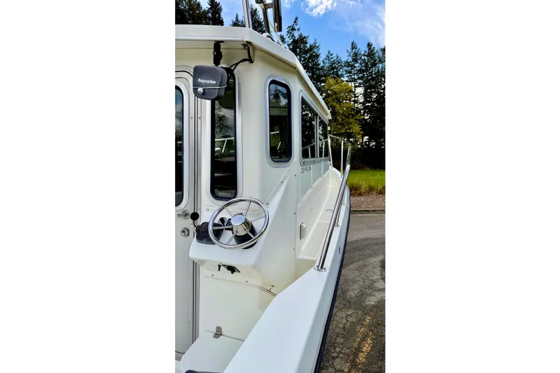 Slide: The Image of 2006 Osprey Legend boat side view with steering wheel and Raymarine equipment. - 8