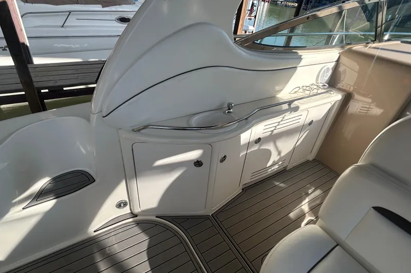 Slide: The Image of 2004 Sea Ray 360 Sundancer cockpit with white seating and wooden steering wheel. - 13