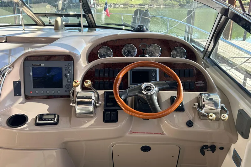 Slide: The Image of 2004 Sea Ray 360 Sundancer helm with wood steering wheel and navigation controls. - 14