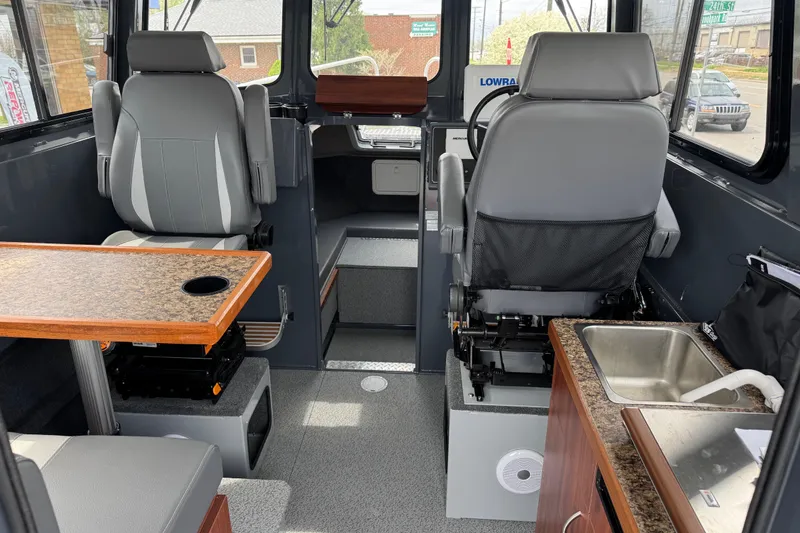 Slide: The Image of Interior of 2025 Hewescraft 240 Pacific Cruiser with seating, table, and sink. - 17