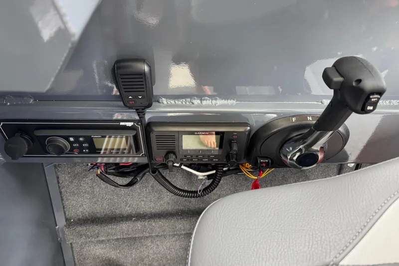 Slide: The Image of Control panel of 2025 Hewescraft 240 Pacific Cruiser with radio and throttle. - 22