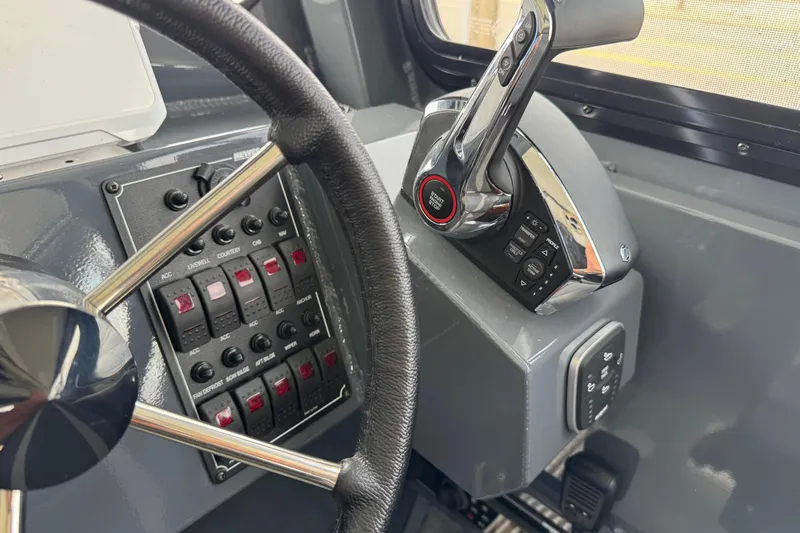 Slide: The Image of Steering wheel and controls of 2025 Hewescraft 240 Pacific Cruiser boat cockpit. - 23