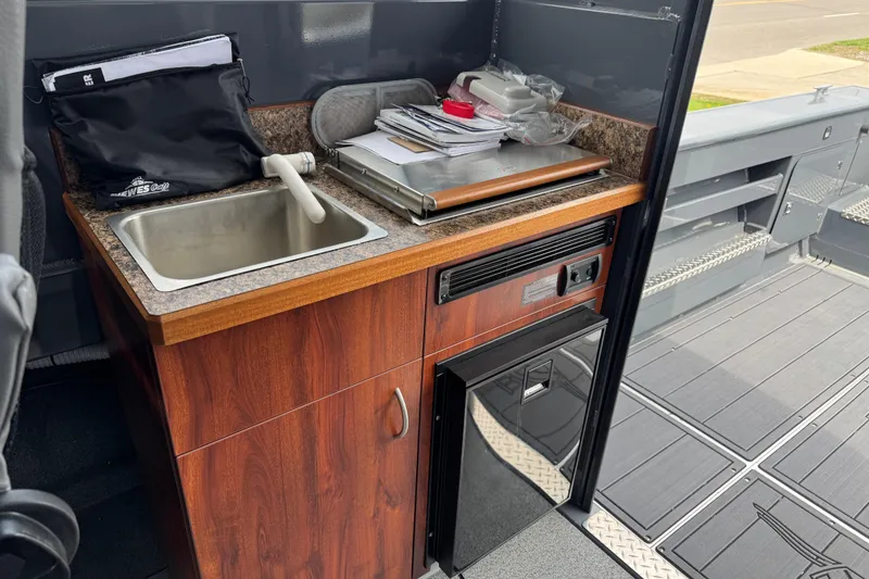 Slide: The Image of Compact kitchen area in 2025 Hewescraft 240 Pacific Cruiser with sink and storage. - 24