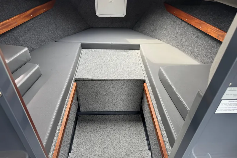 Slide: The Image of 2025 Hewescraft 240 Pacific Cruiser cabin interior with gray seating and wood accents. - 27