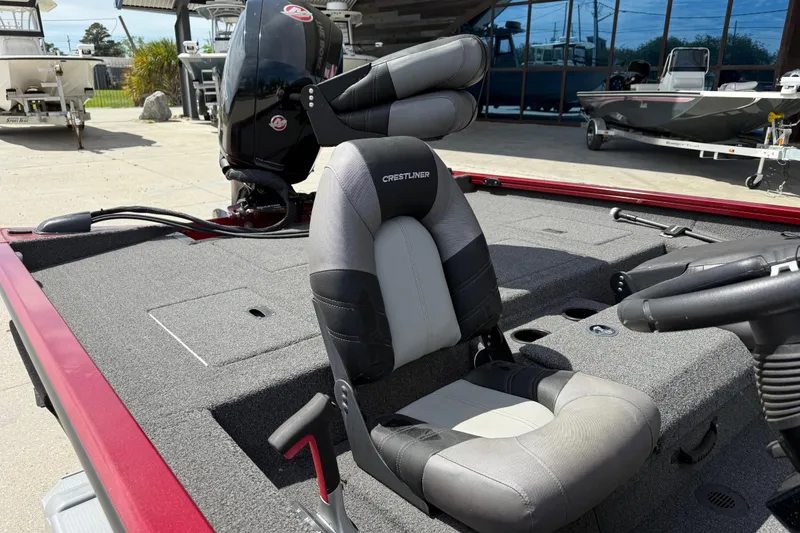 Slide: The Image of 2023 Crestliner 1850 SC boat interior with seating and motor, displayed outdoors. - 12