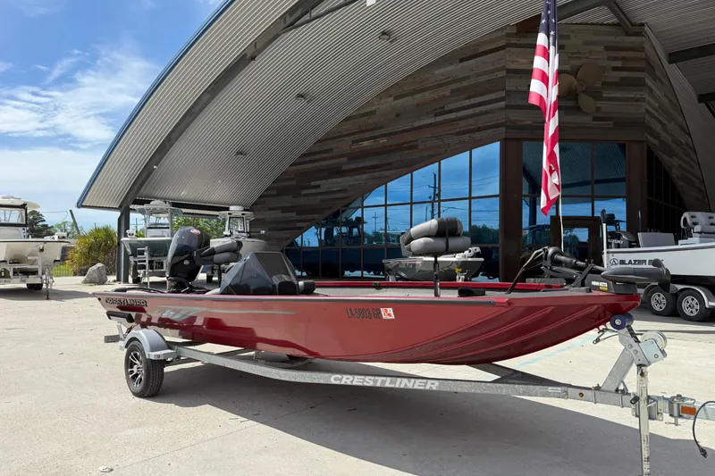 Slide: The Image of 2023 Crestliner 1850 SC boat on trailer outside modern building. - 3