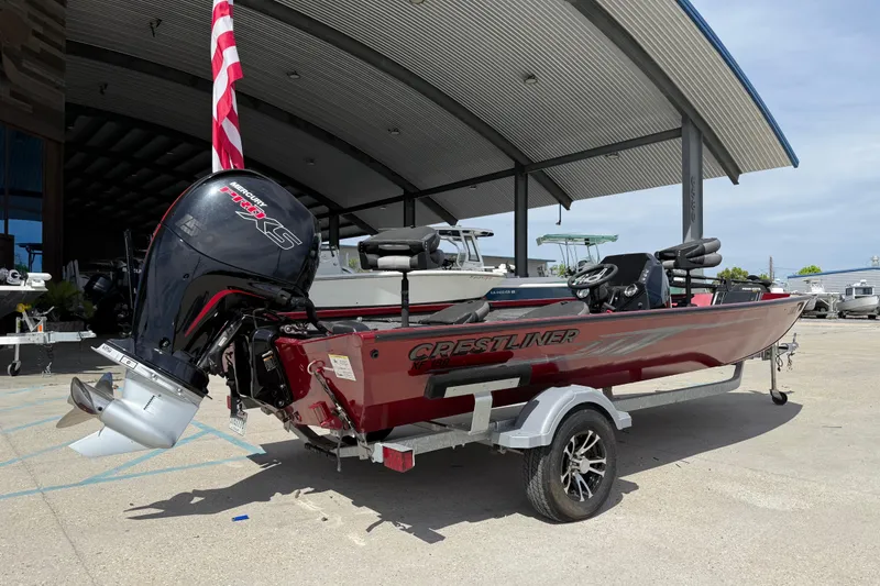 Slide: The Image of 2023 Crestliner 1850 SC boat with Mercury engine on trailer, parked outdoors. - 4