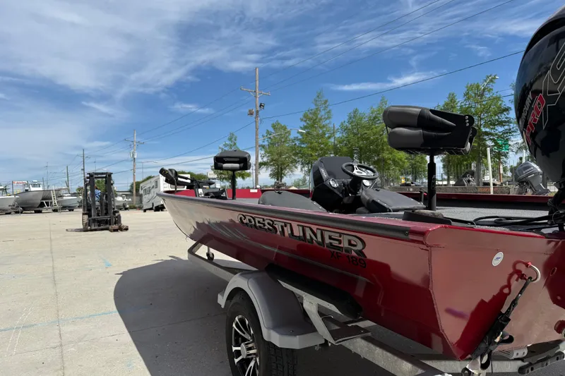 Slide: The Image of 2023 Crestliner 1850 SC boat in a parking lot under a clear blue sky. - 6