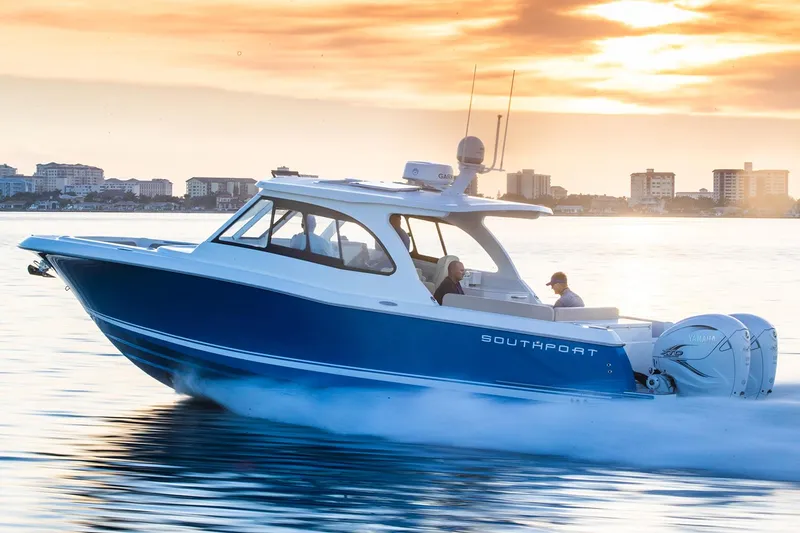 Slide: The Image of Manufacturer Provided Image: 2025 Southport 33 DC boat cruising on water at sunset, city skyline in background. - 3