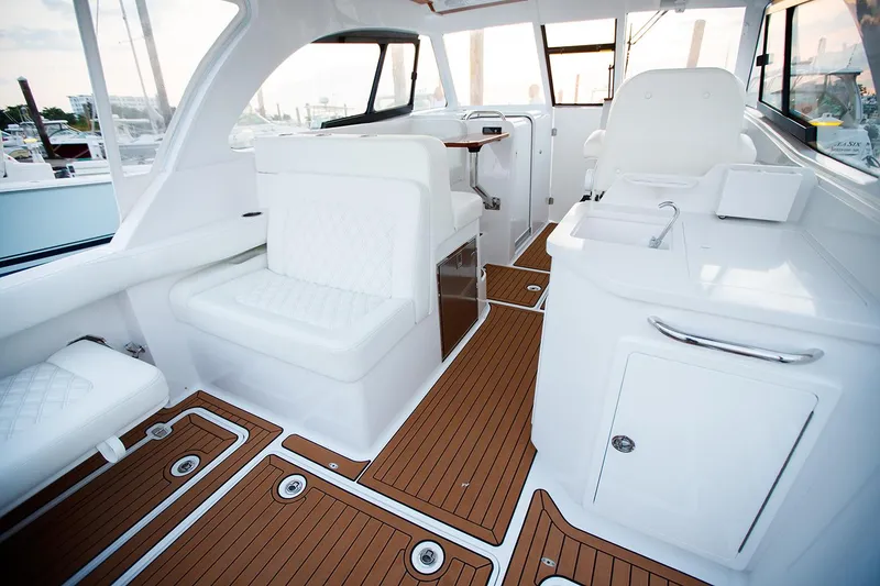 Slide: The Image of Manufacturer Provided Image: 2025 Southport 33 DC boat interior with white seating and wood flooring. - 9