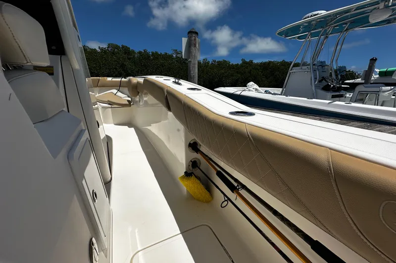 Slide: The Image of 2019 Pioneer 266 Pelagic boat interior with beige seating and fishing rod holders. - 20