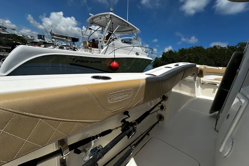 Slide: The Image of 2019 Pioneer 266 Pelagic boat interior with rod holders, docked near another vessel. - 21