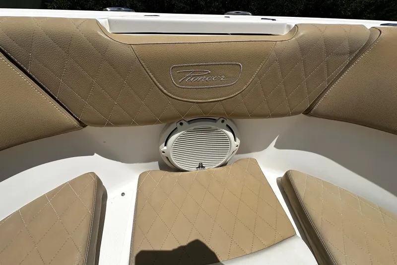 Slide: The Image of 2019 Pioneer 266 Pelagic boat interior with tan diamond-stitched upholstery and speaker. - 26