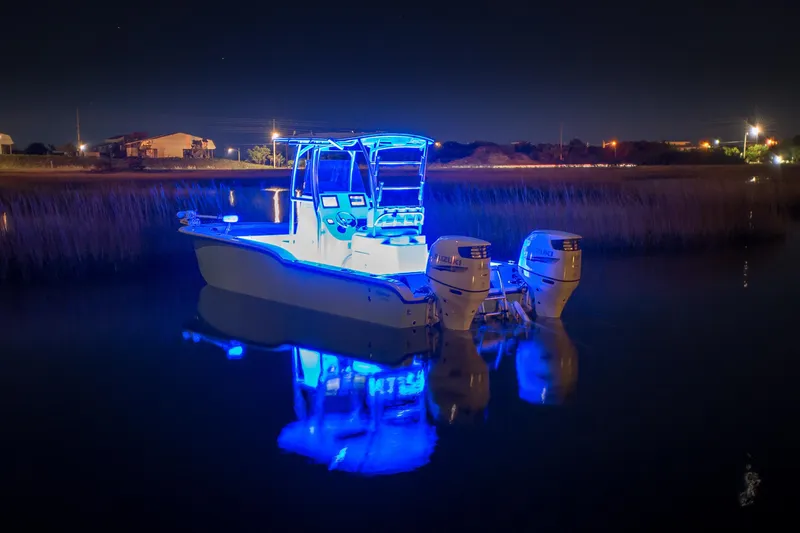 Slide: The Image of 2026 Tideline 235 Hybrid boat illuminated with blue lights at night on calm water. - 11