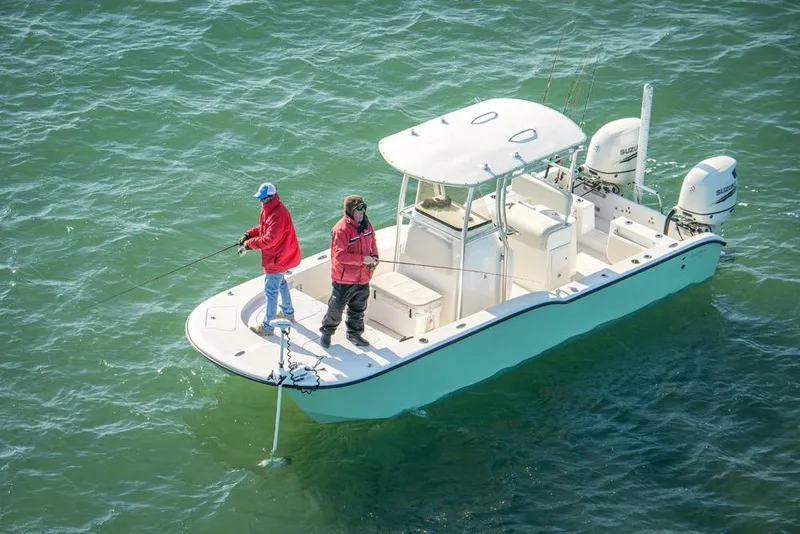 Slide: The Image of Two people fishing on a 2026 Tideline 235 Hybrid boat in open water. - 2