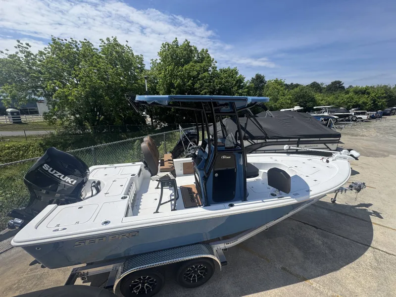 Slide: The Image of 2026 Sea Pro 230 DLX boat on trailer, Suzuki engine, sunny day. - 16