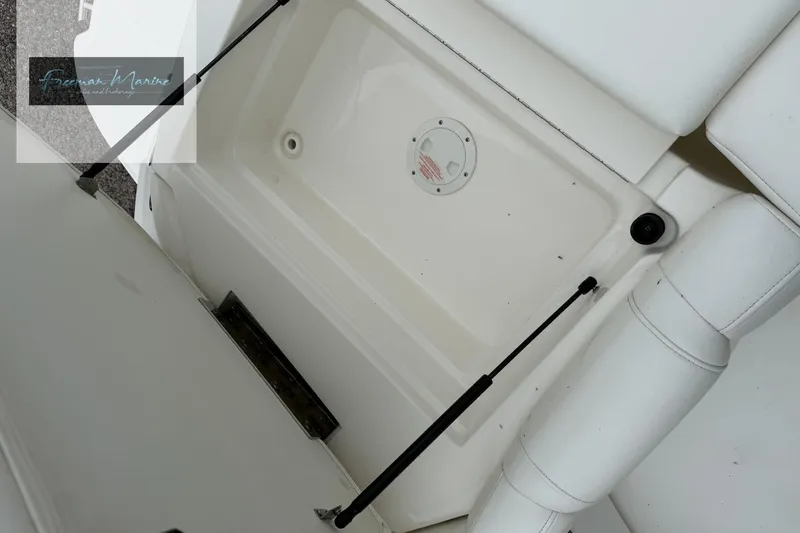 Slide: The Image of 2008 Sea Ray 270 SLX boat storage compartment with white interior and hydraulic supports. - 18