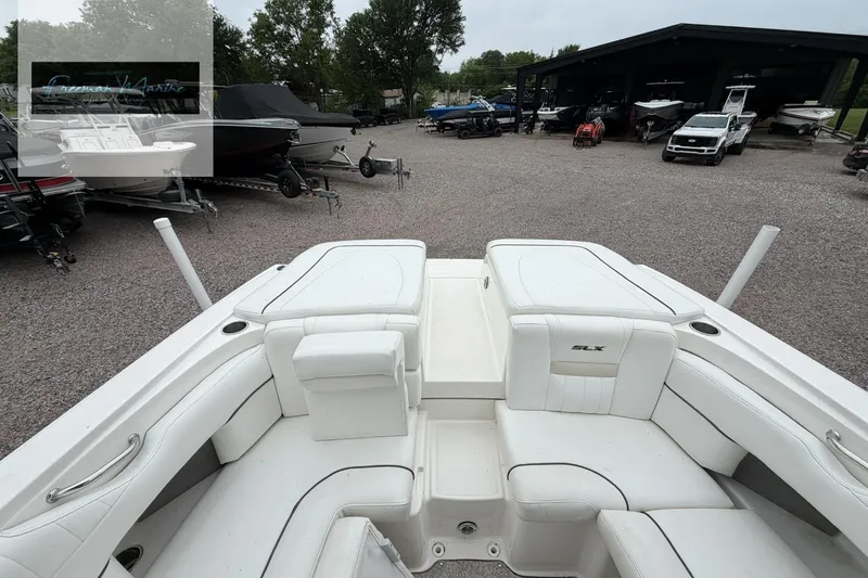 Slide: The Image of 2008 Sea Ray 270 SLX boat with white seating, parked in a marina. - 27