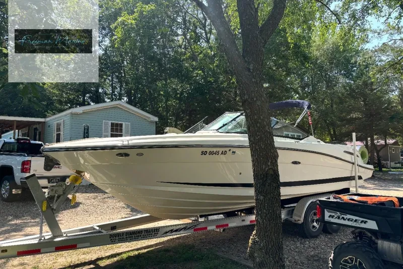 Slide: The Image of 2008 Sea Ray 270 SLX boat on trailer, parked outdoors near trees and a house. - 34