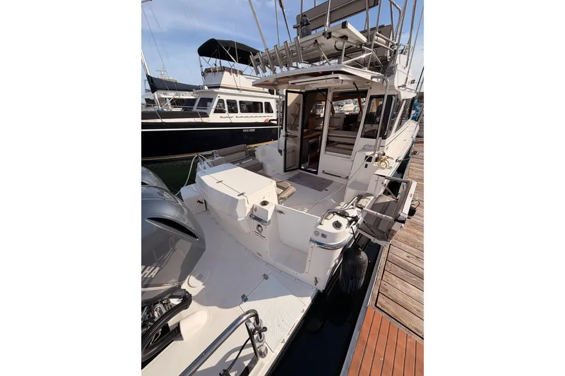 Slide: The Image of 2021 Cutwater C-32 CB boat docked, featuring dual outboard engines, in a marina setting. - 12