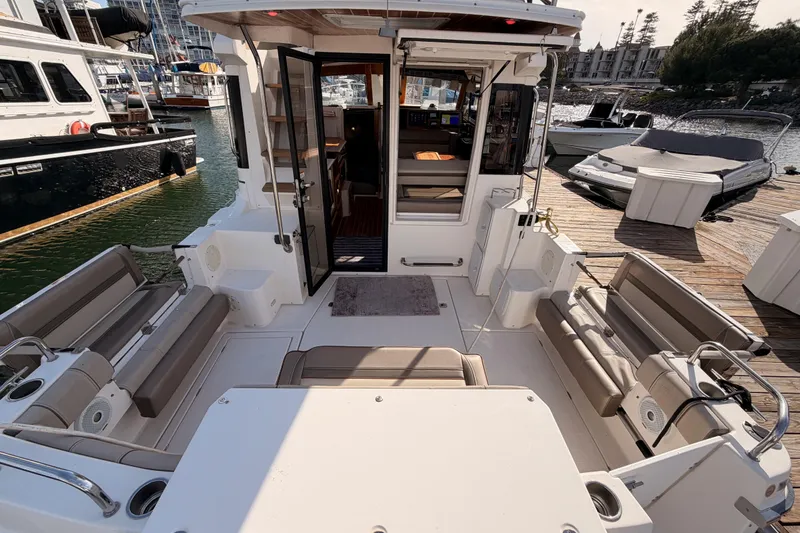 Slide: The Image of 2021 Cutwater C-32 CB boat docked in a marina under a sunny sky. - 13