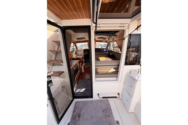 Slide: The Image of 2021 Cutwater C-32 CB boat docked, featuring a cushioned seating area and marina view. - 35