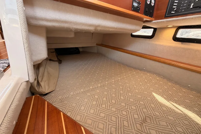 Slide: The Image of 2021 Cutwater C-32 CB interior with beige seating and wooden table, dockside view. - 42