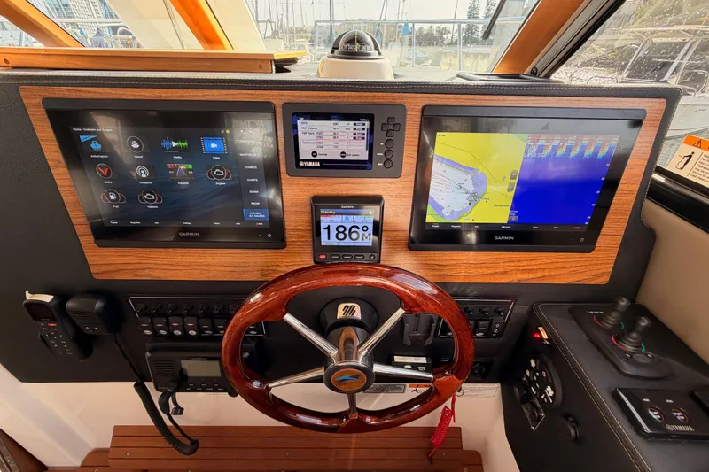 Slide: The Image of 2021 Cutwater C-32 CB boat interior with helm, leather seating, and wood accents. - 53