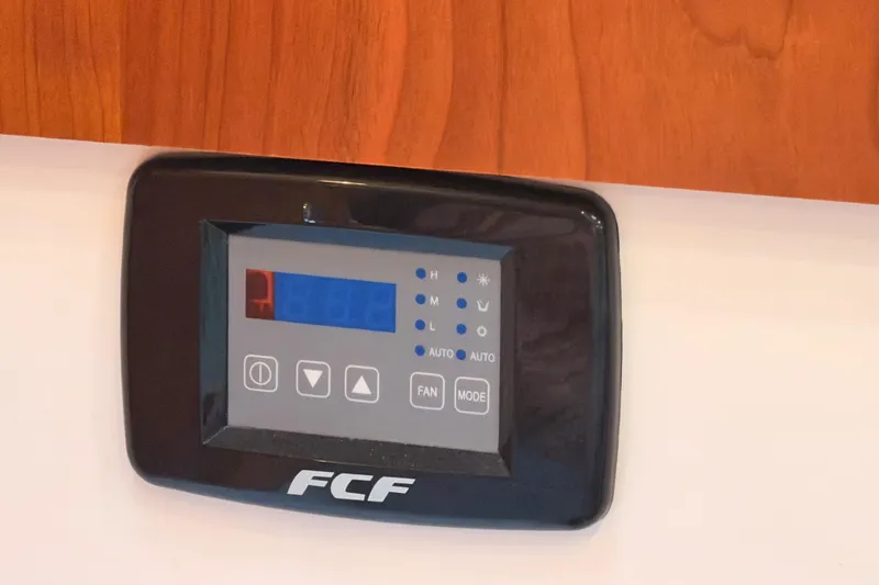 Slide: The Image of 2021 Cutwater C-32 CB interior with TV, wooden cabinetry, and striped curtain. - 62