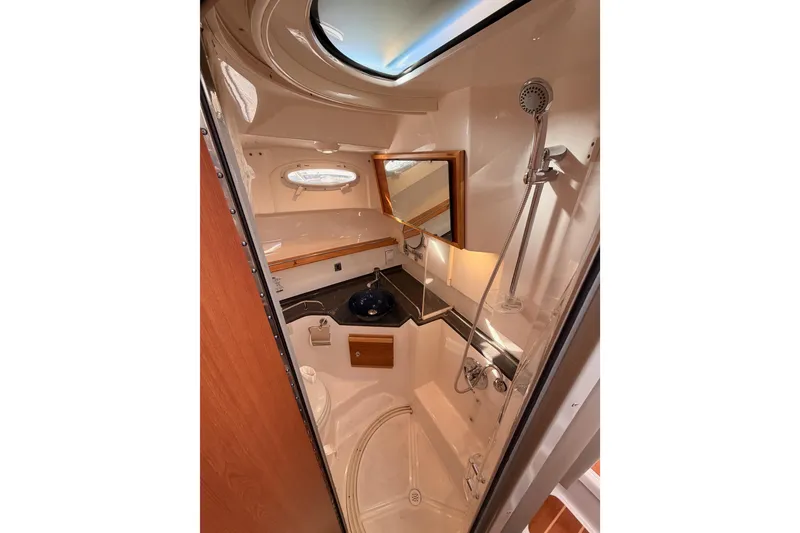 Slide: The Image of 2021 Cutwater C-32 CB cabin interior with anchor-themed bedding and cozy lighting. - 63