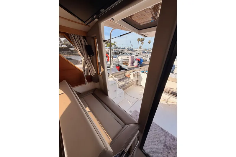 Slide: The Image of 2021 Cutwater C-32 CB interior with built-in Dometic fridge on wooden flooring. - 74