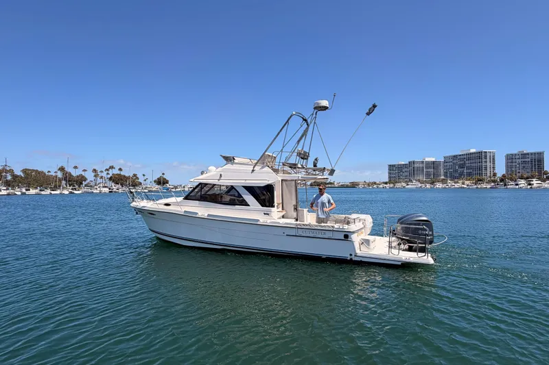 Slide: The Image of 2021 Cutwater C-32 CB boat cruising in a marina with buildings in the background. - 81