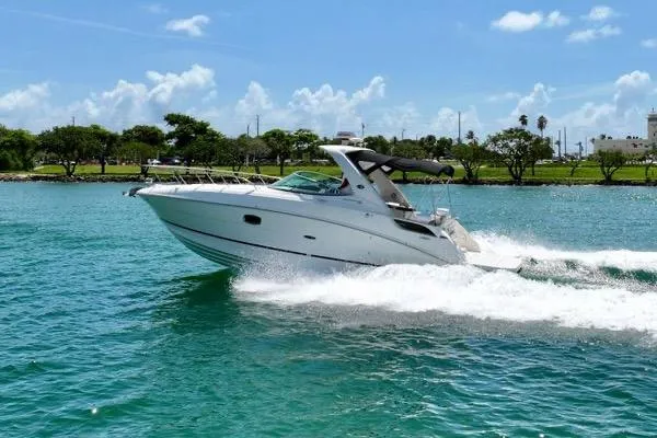 The Image of 2012 Sea Ray Sundancer 310 cruising on clear blue water under a sunny sky. - 0