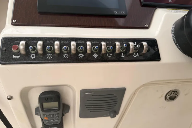 Slide: The Image of Control panel of a 2012 Sea Ray Sundancer 310 boat with various switches. - 11