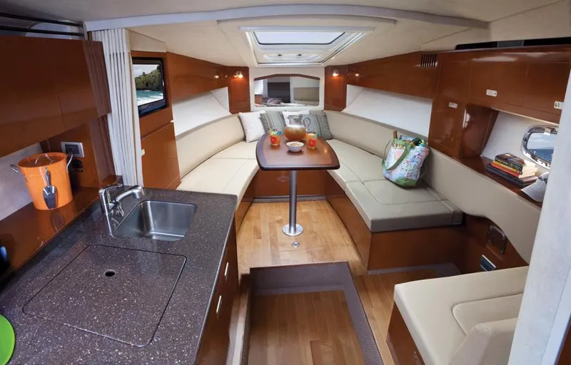 Slide: The Image of Manufacturer Provided Image: Interior of 2012 Sea Ray 310 Sundancer yacht with modern kitchen and cozy seating area. - 17