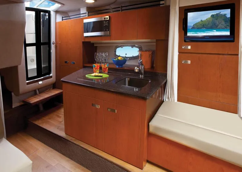 Slide: The Image of Manufacturer Provided Image: Interior of 2012 Sea Ray 310 Sundancer with kitchenette, microwave, sink, and TV. - 18