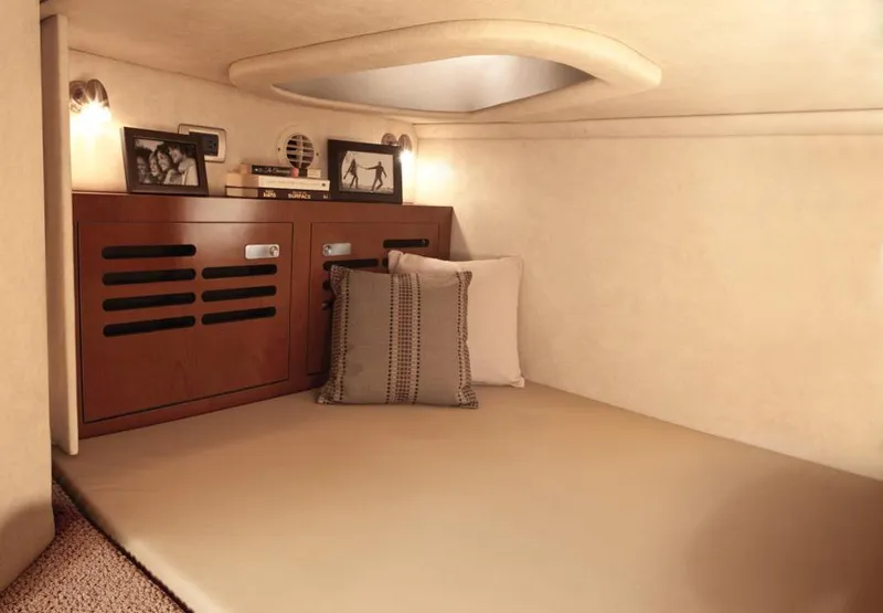 Slide: The Image of Manufacturer Provided Image: Cozy cabin interior of 2012 Sea Ray 310 Sundancer with pillows and wooden storage. - 19