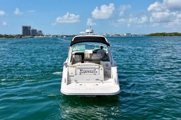 Slide: The Image of 2012 Sea Ray Sundancer 310 yacht cruising on open water under a clear blue sky. - 2