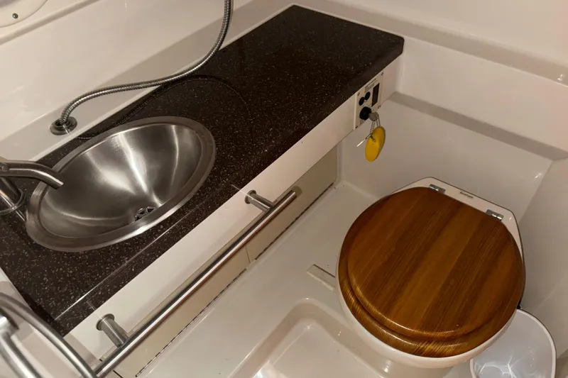Slide: The Image of 2012 Sea Ray Sundancer 310 bathroom with stainless steel sink and wooden toilet seat. - 28