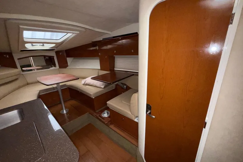 Slide: The Image of Interior of 2012 Sea Ray Sundancer 310, featuring cozy seating and wooden finishes. - 29