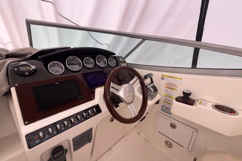 Slide: The Image of 2012 Sea Ray Sundancer 310 helm with gauges, steering wheel, and control panel. - 3