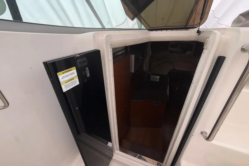 Slide: The Image of 2012 Sea Ray Sundancer 310 cabin entrance with open door, revealing interior space. - 33