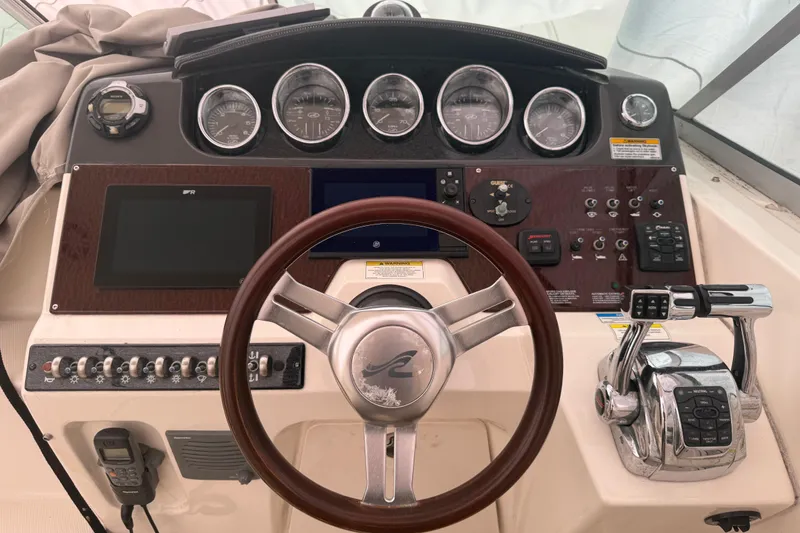 Slide: The Image of Control panel of a 2012 Sea Ray Sundancer 310 boat with steering wheel and gauges. - 4