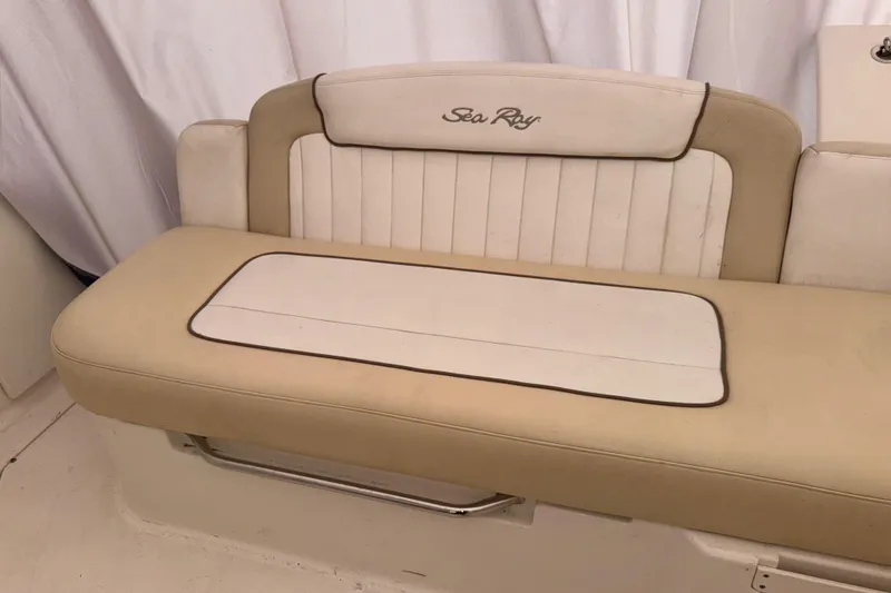 Slide: The Image of 2012 Sea Ray Sundancer 310 beige seating with embroidered logo, showcasing luxury boat interior. - 8