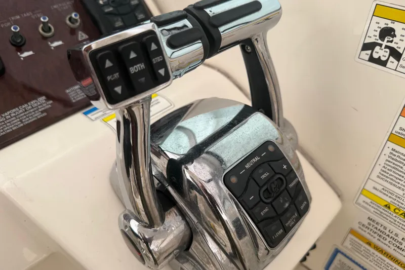 Slide: The Image of Close-up of 2012 Sea Ray Sundancer 310 throttle controls with buttons and levers. - 9