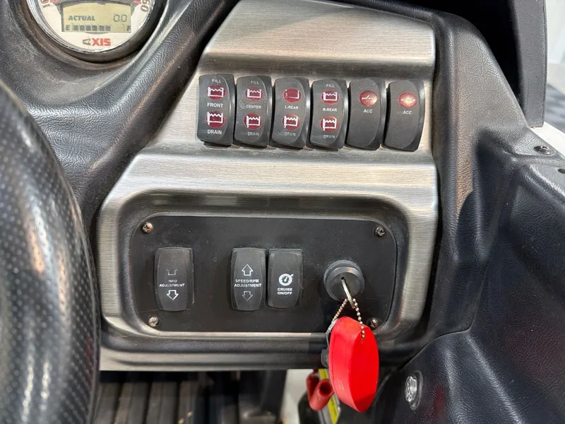 Slide: The Image of Dashboard of a 2011 Axis A20 boat with switches and ignition key. - 16